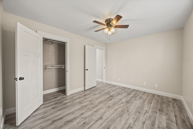 unfurnished bedroom featuring ceiling fan, a closet, and light wood-type flooring