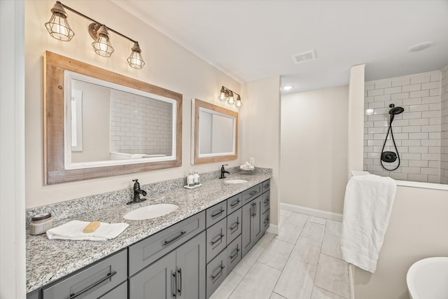 bathroom featuring a washtub, vanity, and tile patterned flooring