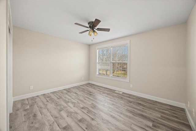 spare room with ceiling fan and light wood-type flooring