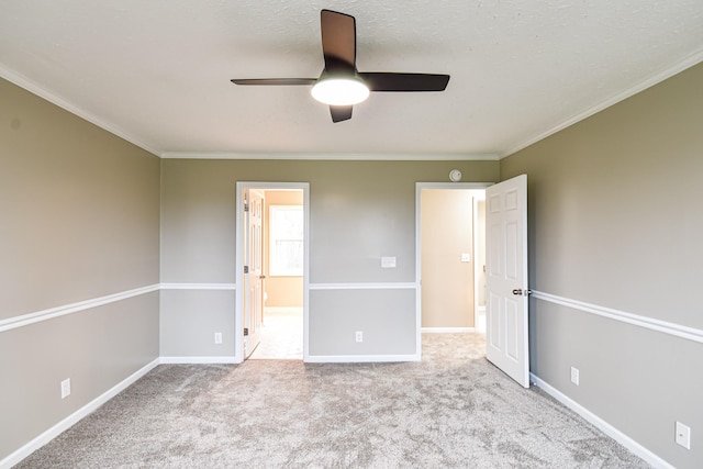 unfurnished bedroom with ceiling fan, light colored carpet, and crown molding