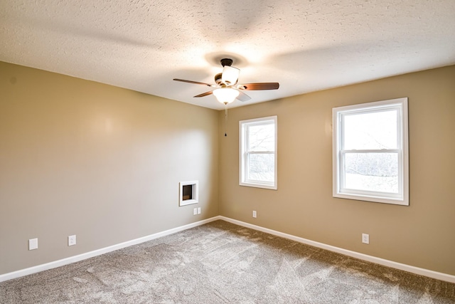 carpeted empty room with ceiling fan and a textured ceiling