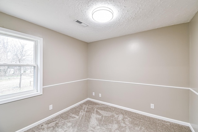 carpeted spare room featuring a textured ceiling