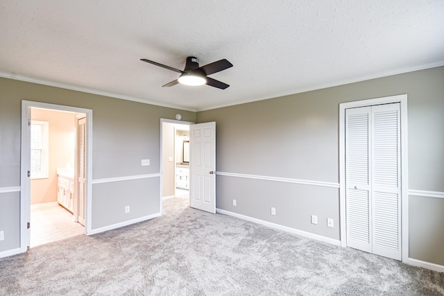 unfurnished bedroom featuring ceiling fan, ensuite bathroom, and ornamental molding