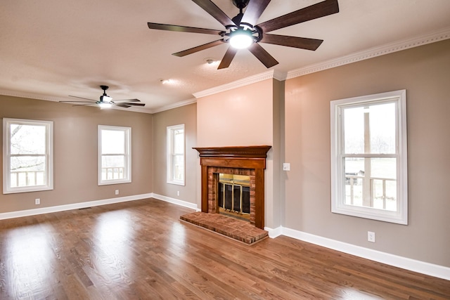 unfurnished living room with hardwood / wood-style flooring, a brick fireplace, and a healthy amount of sunlight