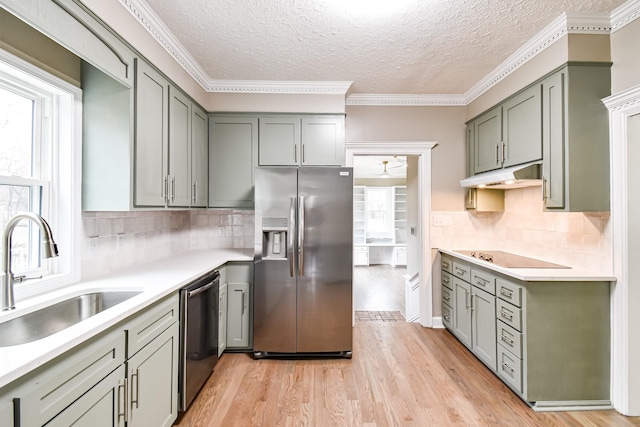 kitchen with decorative backsplash, sink, light hardwood / wood-style flooring, and appliances with stainless steel finishes