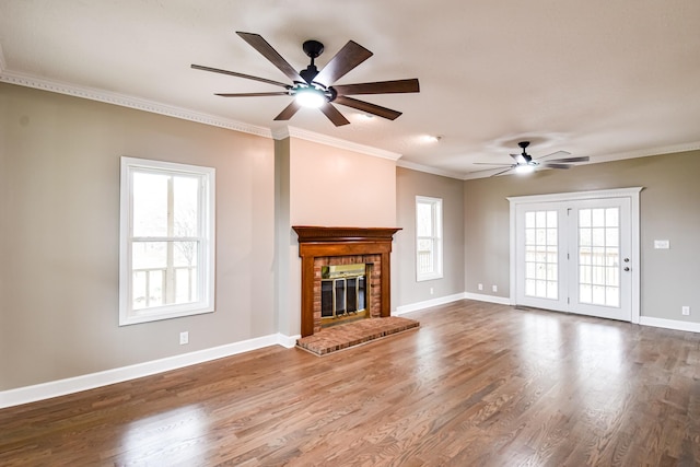 unfurnished living room with hardwood / wood-style floors, ceiling fan, crown molding, and a brick fireplace