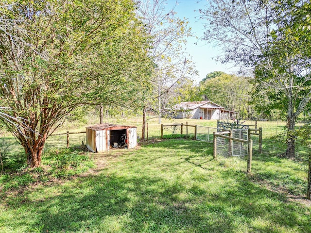 view of yard featuring a rural view and a storage shed