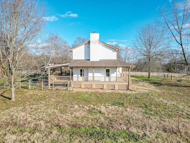 rear view of property featuring a lawn and a wooden deck