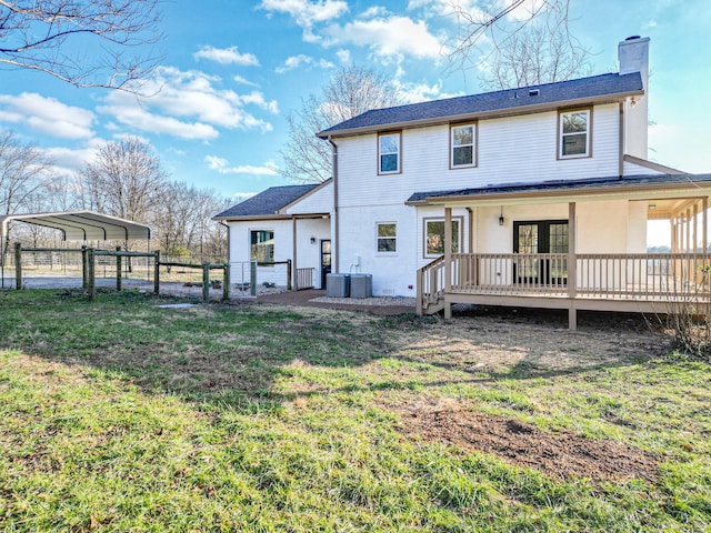 back of property with a carport, a yard, a wooden deck, and french doors