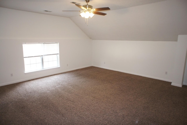 bonus room with dark colored carpet, vaulted ceiling, and ceiling fan