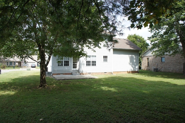 rear view of property featuring a patio and a lawn