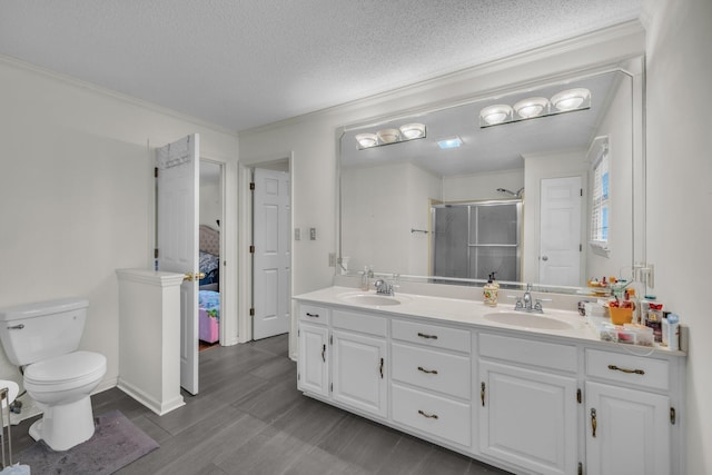 bathroom with vanity, a shower with shower door, toilet, a textured ceiling, and wood-type flooring