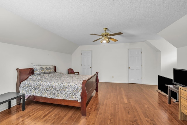 bedroom featuring wood-type flooring, a textured ceiling, ceiling fan, and lofted ceiling