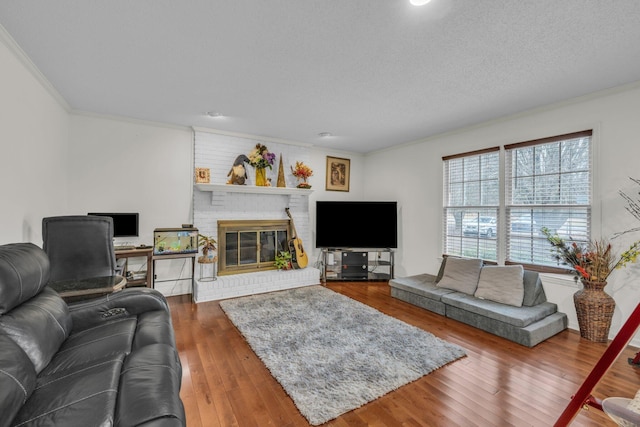 living room with crown molding, a fireplace, a textured ceiling, and hardwood / wood-style flooring