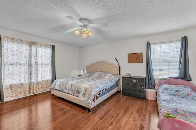 bedroom with hardwood / wood-style flooring, ceiling fan, and a textured ceiling