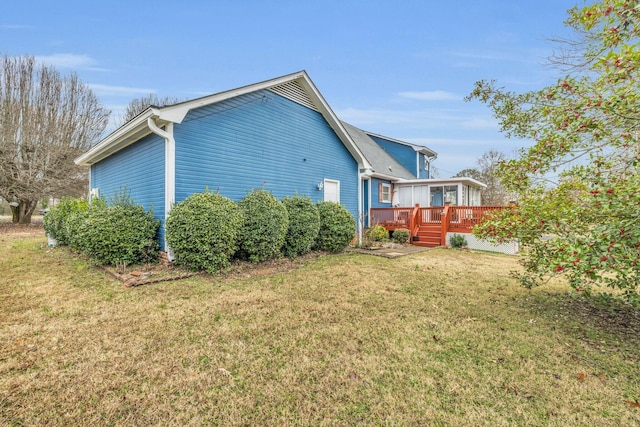 rear view of property featuring a yard and a wooden deck