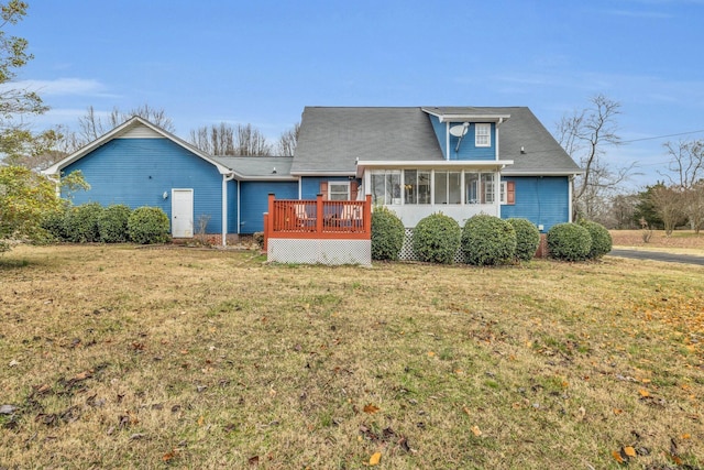 view of front facade with a front yard, a wooden deck, and a sunroom