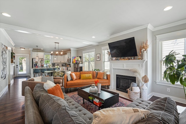 living room featuring hardwood / wood-style flooring, a wealth of natural light, and crown molding