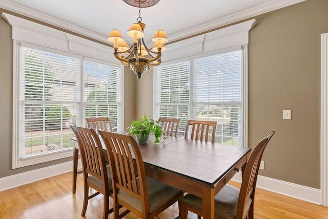 dining area featuring light hardwood / wood-style flooring, an inviting chandelier, and ornamental molding