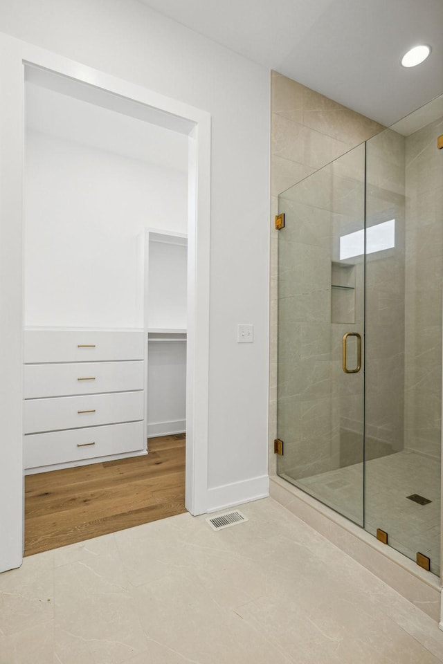 bathroom with tile patterned flooring and walk in shower