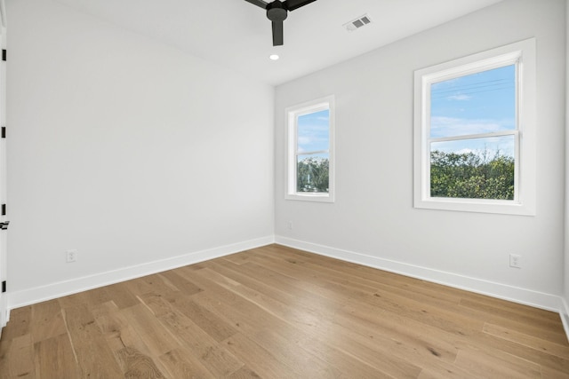 empty room with ceiling fan, plenty of natural light, and light wood-type flooring