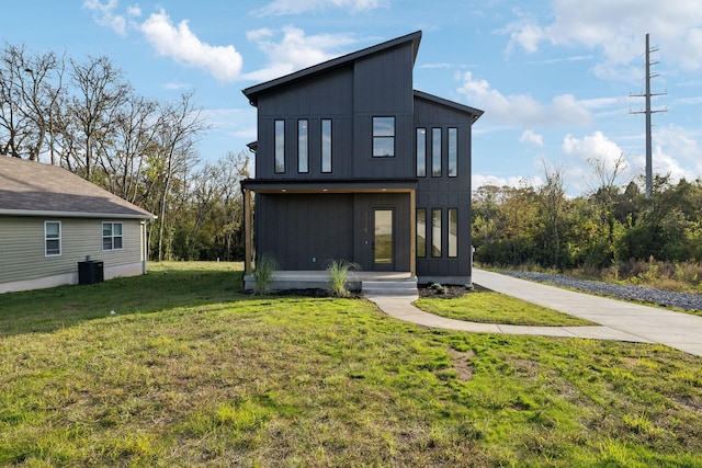 rear view of property featuring a yard and central AC