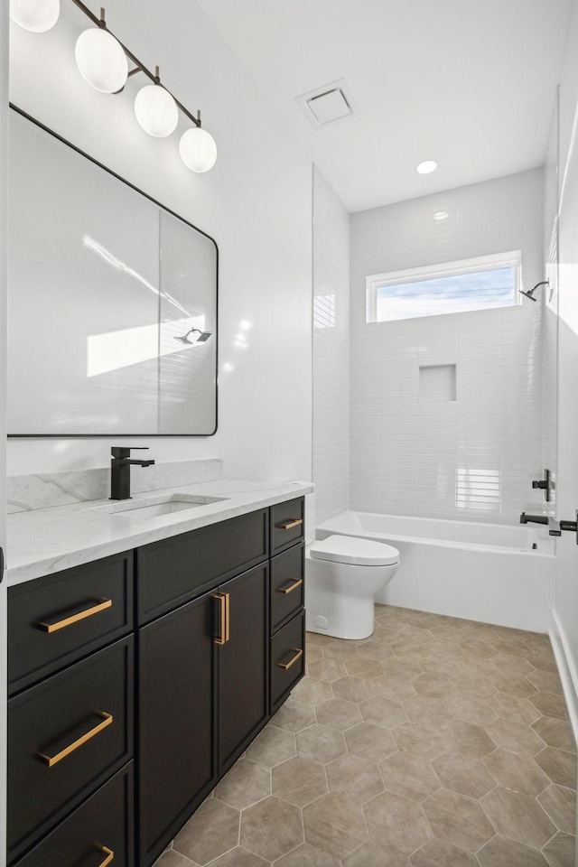 full bathroom with vanity, toilet, and tiled shower / bath