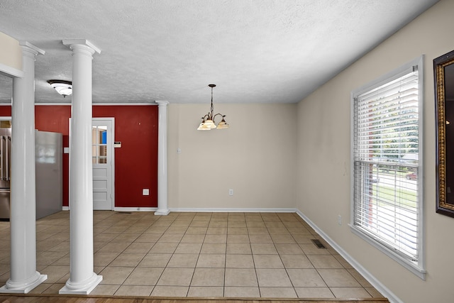 tiled spare room with a notable chandelier