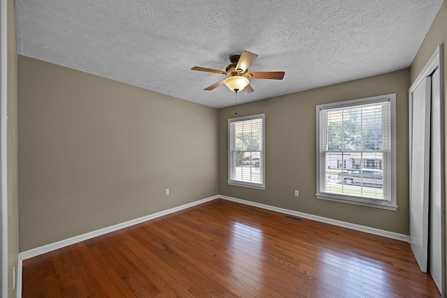 spare room featuring hardwood / wood-style floors, a textured ceiling, and ceiling fan