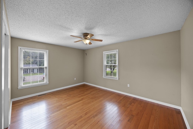 unfurnished room featuring a textured ceiling, light hardwood / wood-style flooring, and ceiling fan