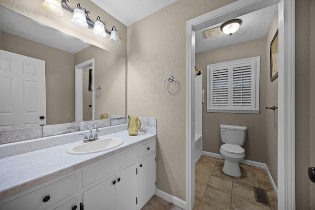 bathroom with vanity, a textured ceiling, and toilet