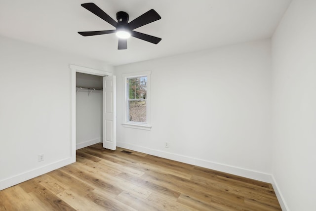 unfurnished bedroom featuring a closet, light hardwood / wood-style floors, and ceiling fan