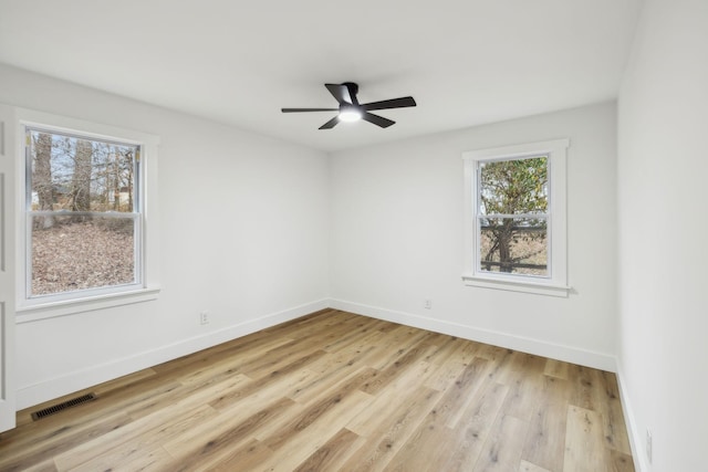 spare room featuring ceiling fan, a healthy amount of sunlight, and light wood-type flooring