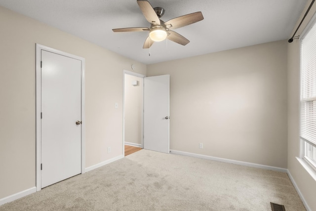 unfurnished bedroom featuring ceiling fan and light carpet