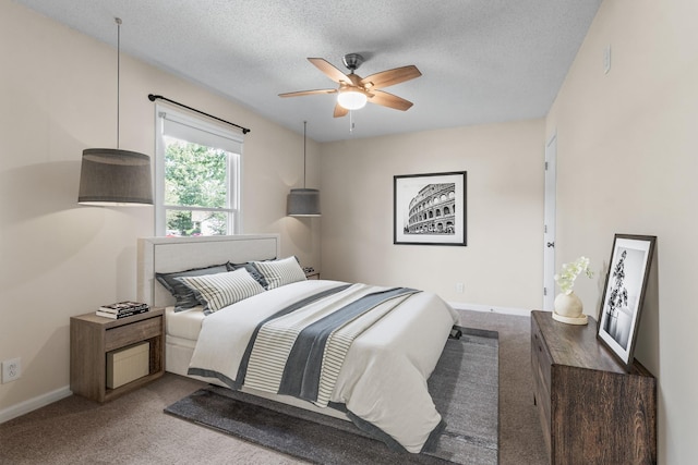 bedroom with a textured ceiling, ceiling fan, and light carpet