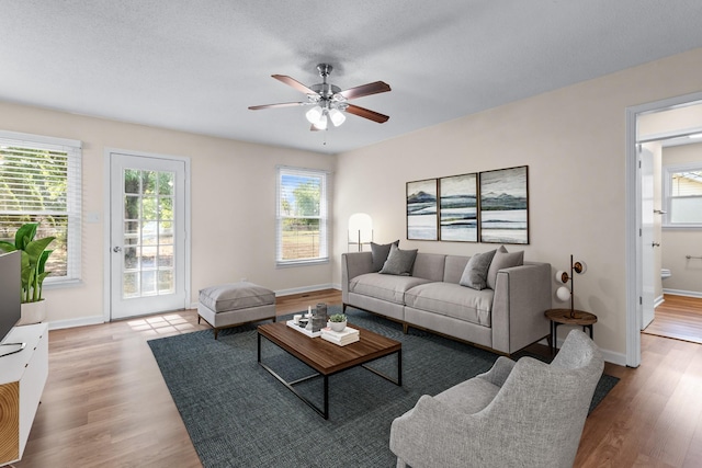 living room with light hardwood / wood-style flooring and ceiling fan