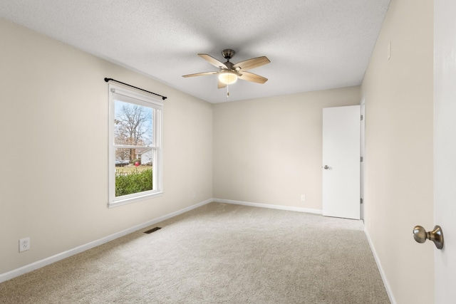 carpeted spare room with ceiling fan and a textured ceiling