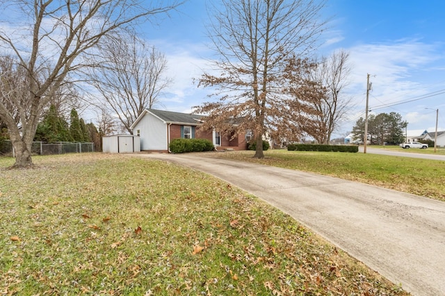 view of front of home featuring a storage unit and a front lawn