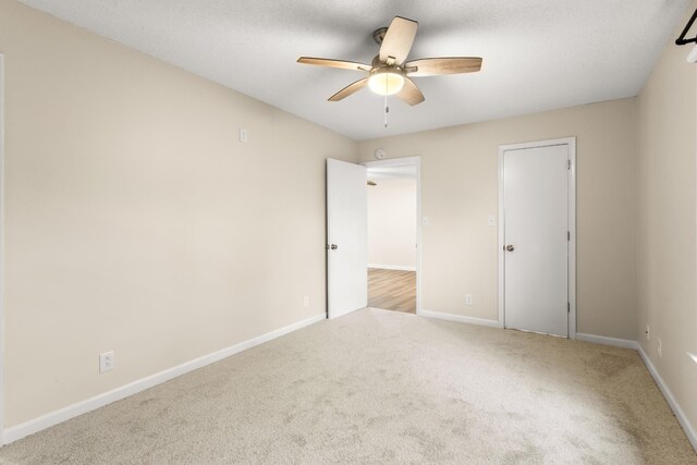 unfurnished room with ceiling fan and light colored carpet