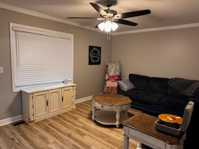 living room with light hardwood / wood-style flooring, ceiling fan, and crown molding