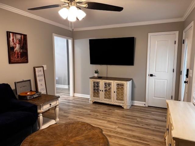 living room with hardwood / wood-style flooring, ceiling fan, and ornamental molding