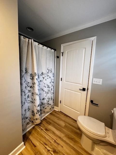 bathroom featuring hardwood / wood-style floors, ornamental molding, and toilet