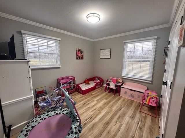 game room featuring light wood-type flooring and ornamental molding