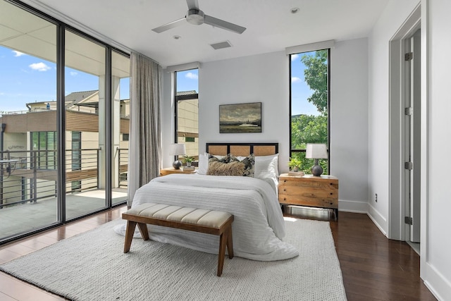 bedroom with access to exterior, ceiling fan, dark wood-type flooring, and a wall of windows