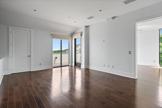 empty room with vaulted ceiling and dark hardwood / wood-style floors