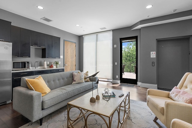 living room featuring sink and light hardwood / wood-style floors