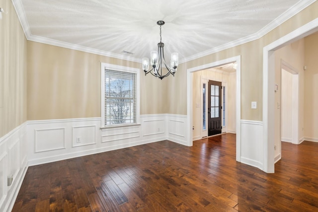 unfurnished dining area featuring ornamental molding, dark wood-type flooring, and a notable chandelier