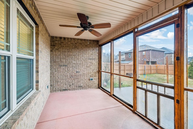 unfurnished sunroom with ceiling fan