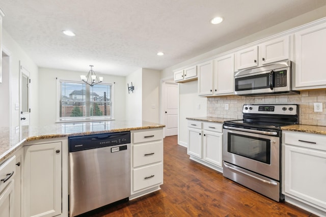 kitchen featuring light stone counters, a notable chandelier, white cabinets, and appliances with stainless steel finishes