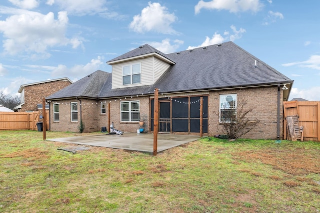 rear view of property with a lawn, a sunroom, and a patio